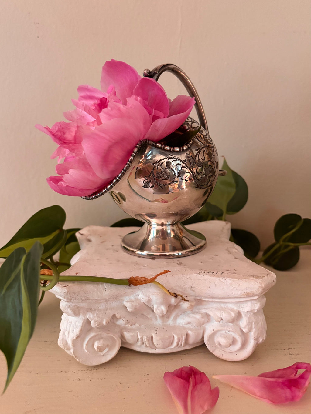 Round silver-plate sugar scuttle with dense acanthus scroll engraving, high arching handle with ball finial, pedestal foot.