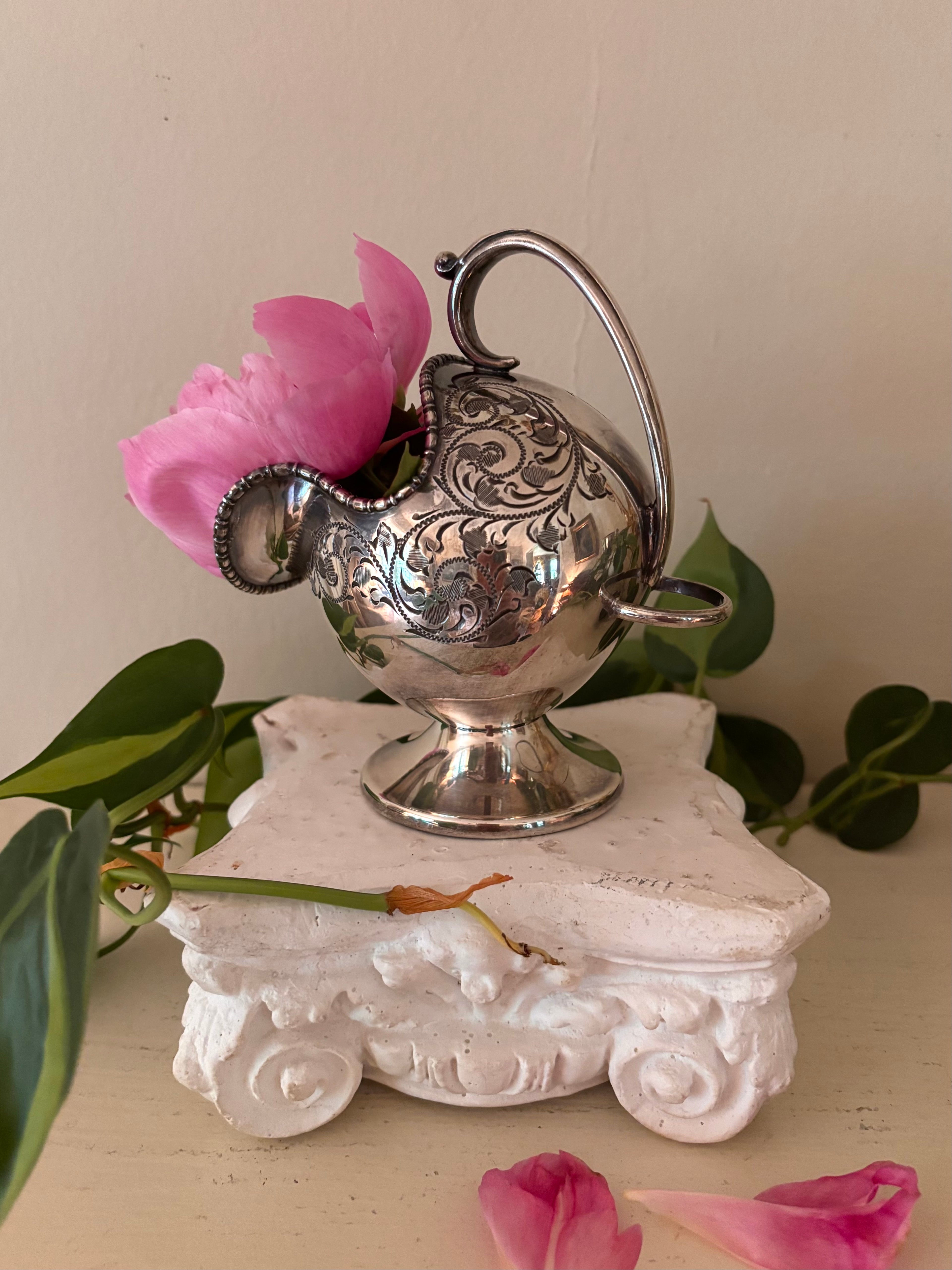 Victorian silver-plate sugar scuttle showing angled beaded rim opening, scroll engraving, and pedestal foot.