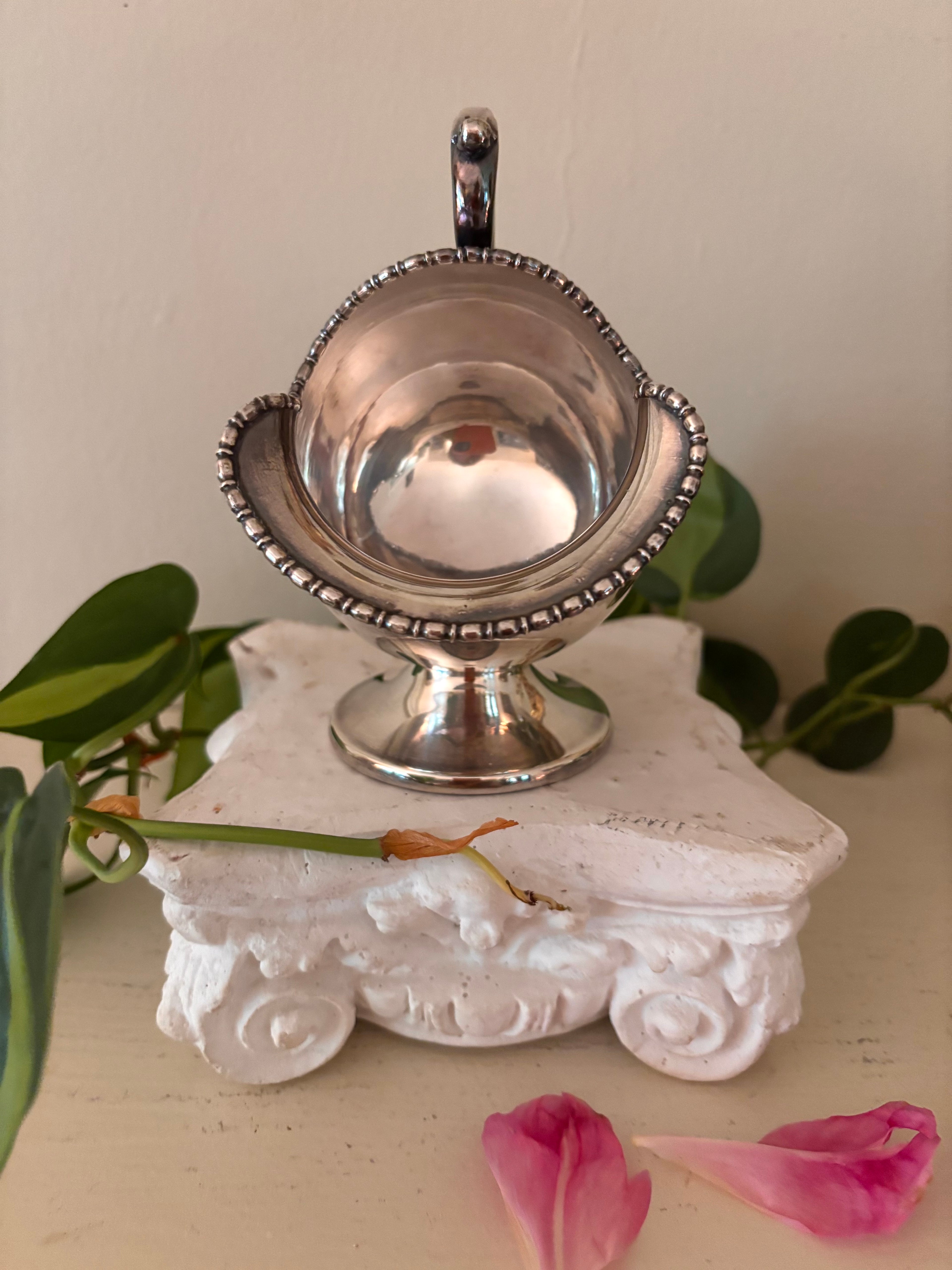 Interior view of silver-plate sugar scuttle showing plain polished bowl and beaded rim border.