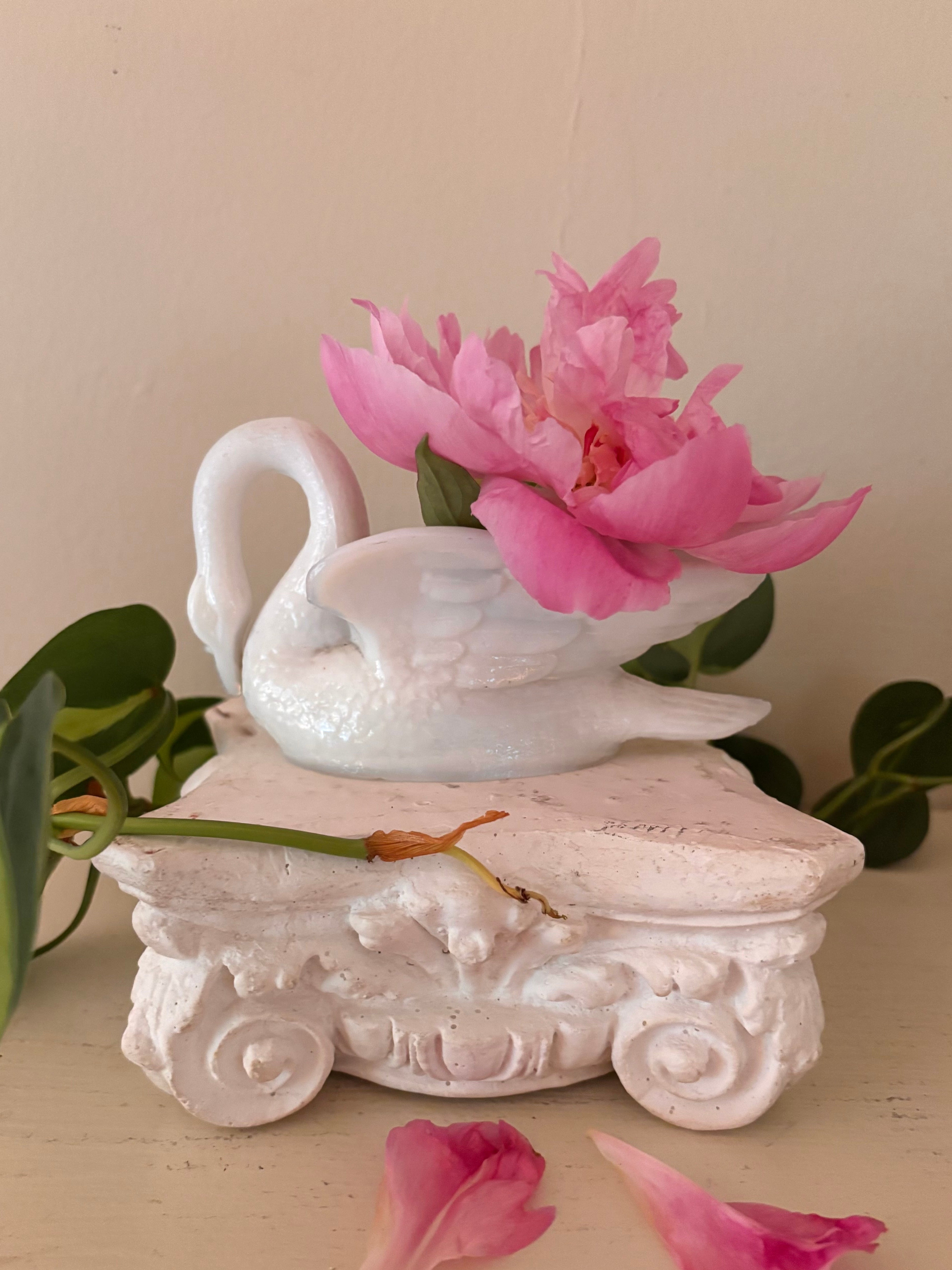 Glossy white porcelain swan figurine with curved neck and layered feather detail, facing left.