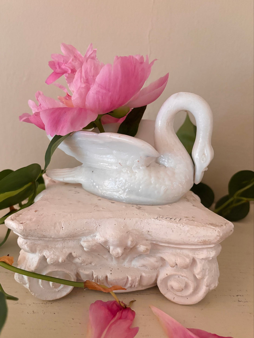 White glazed porcelain swan in profile, neck arching right, smooth body and wing detail.