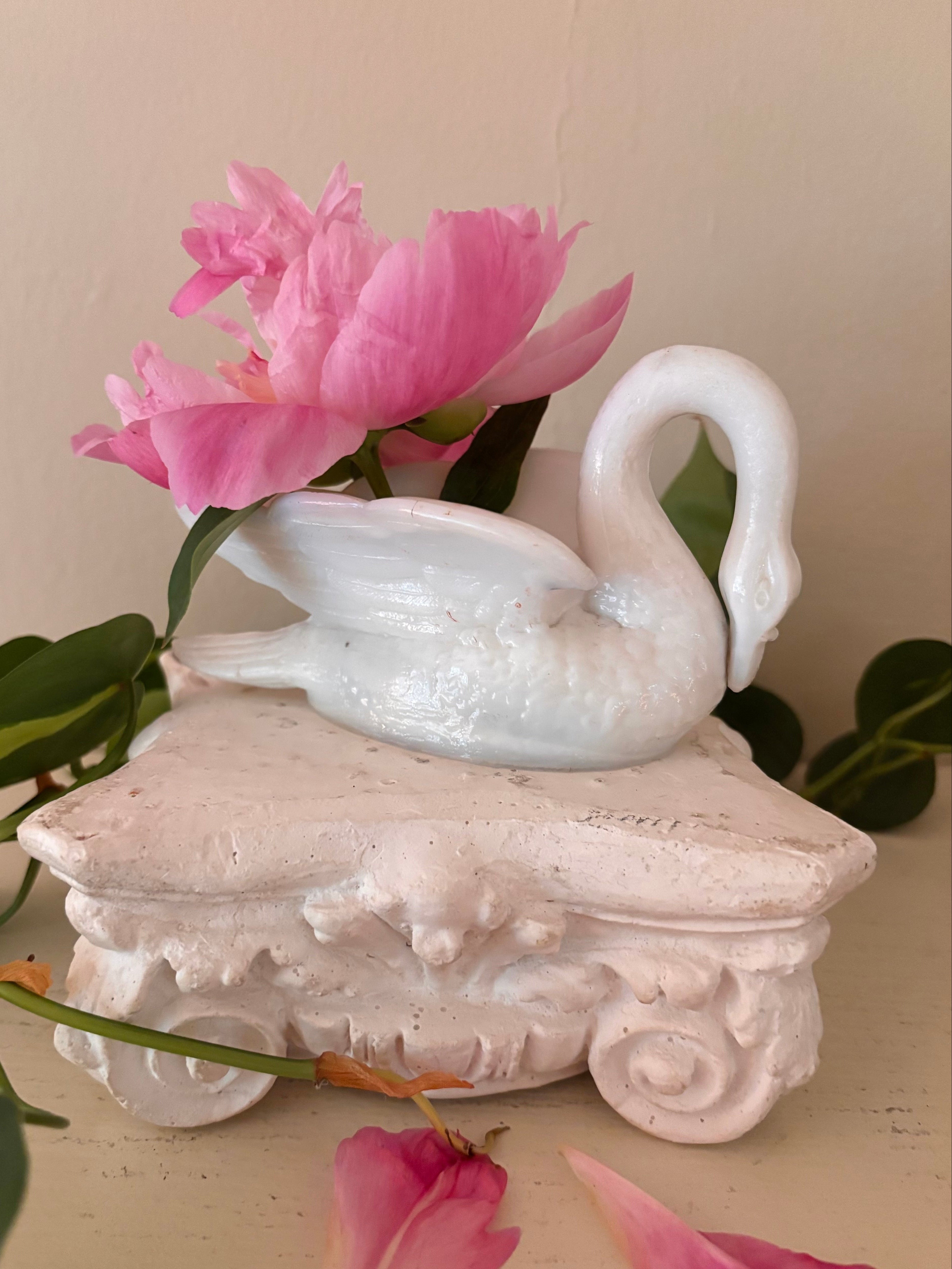 White glazed porcelain swan in profile, neck arching right, smooth body and wing detail.