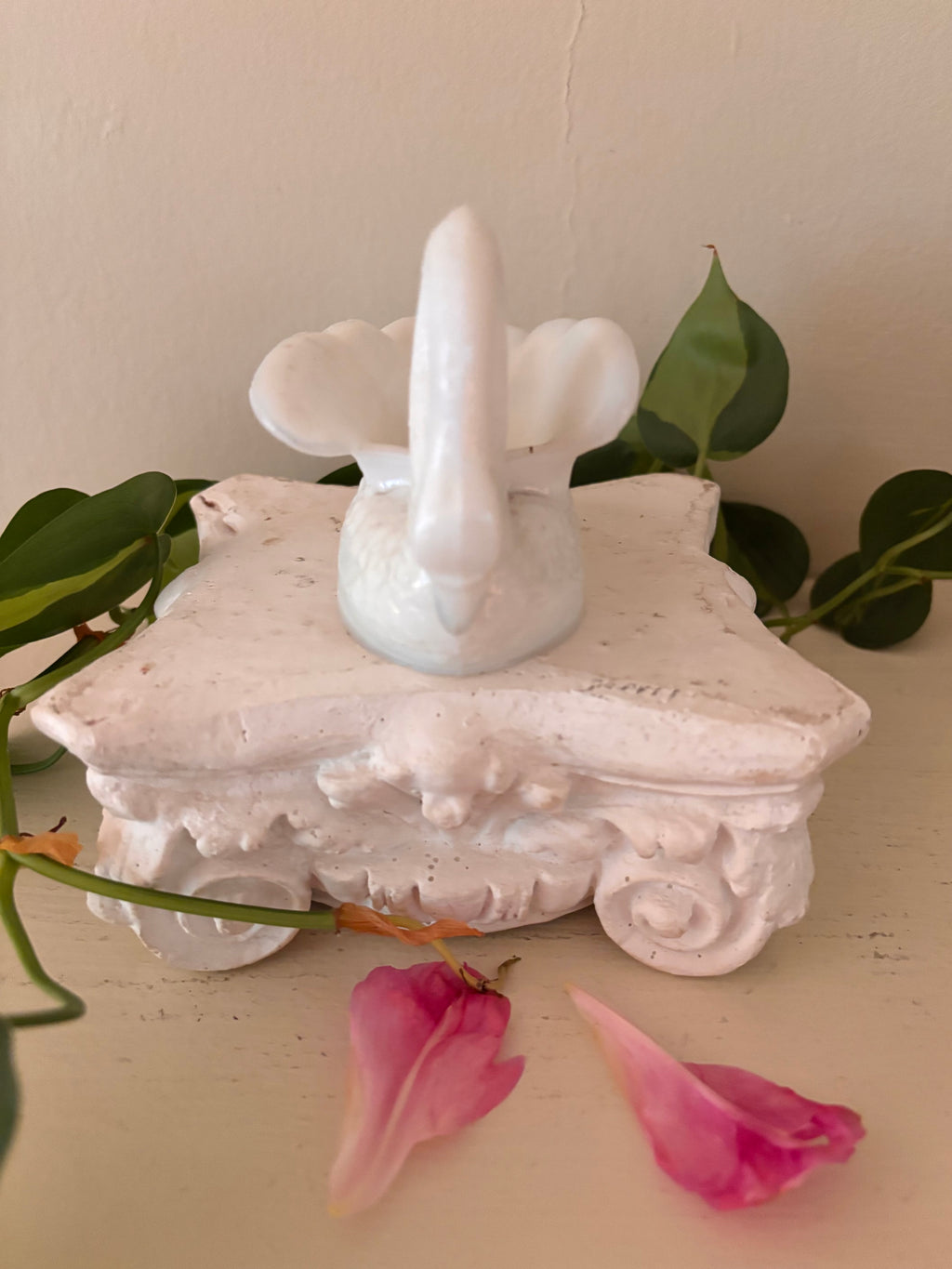 White glazed porcelain swan from front showing face, beak, and wing spread.