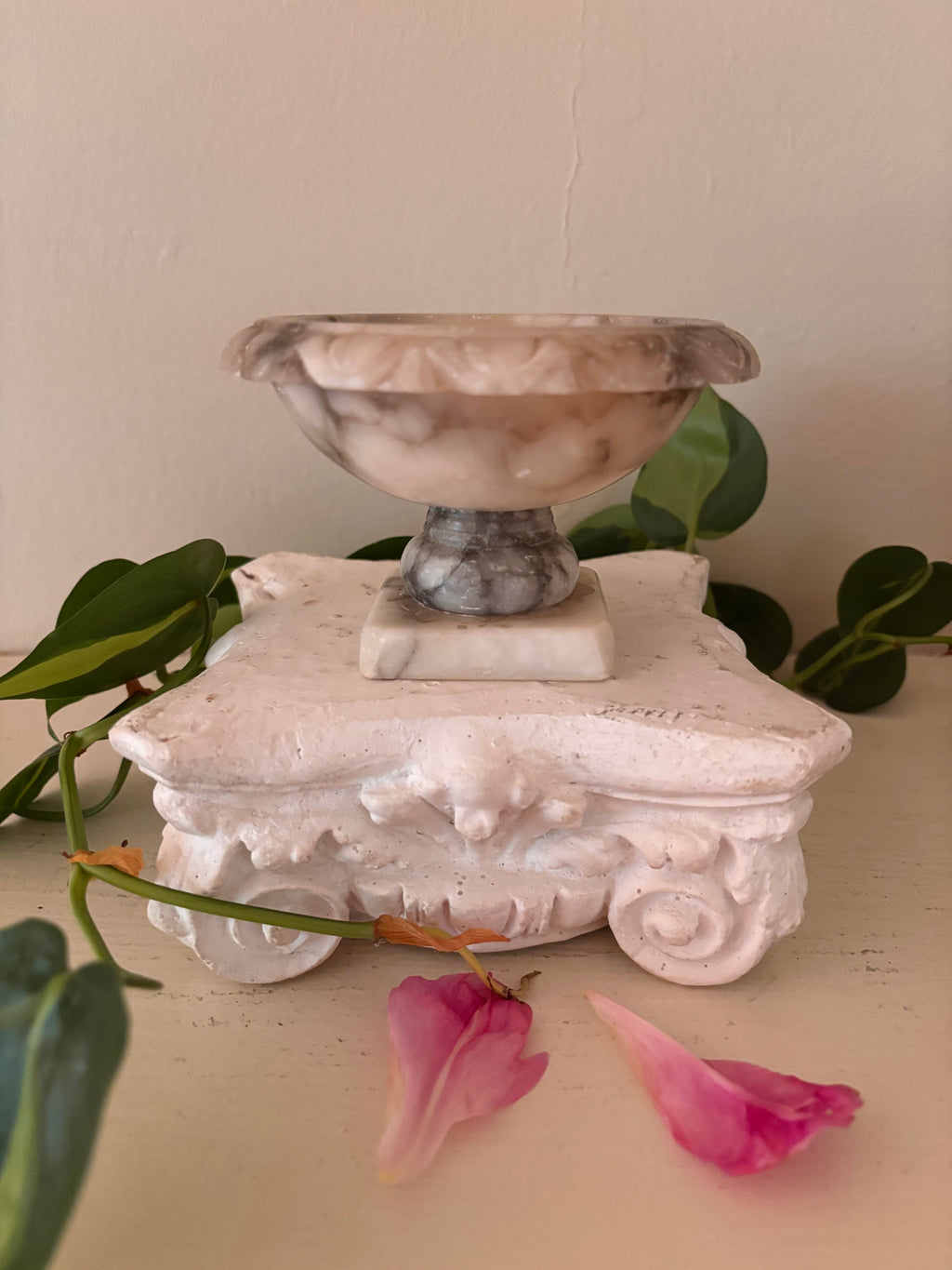 Marble footed compote with carved petal rim, cream and charcoal grey veined stone, short turned pedestal.