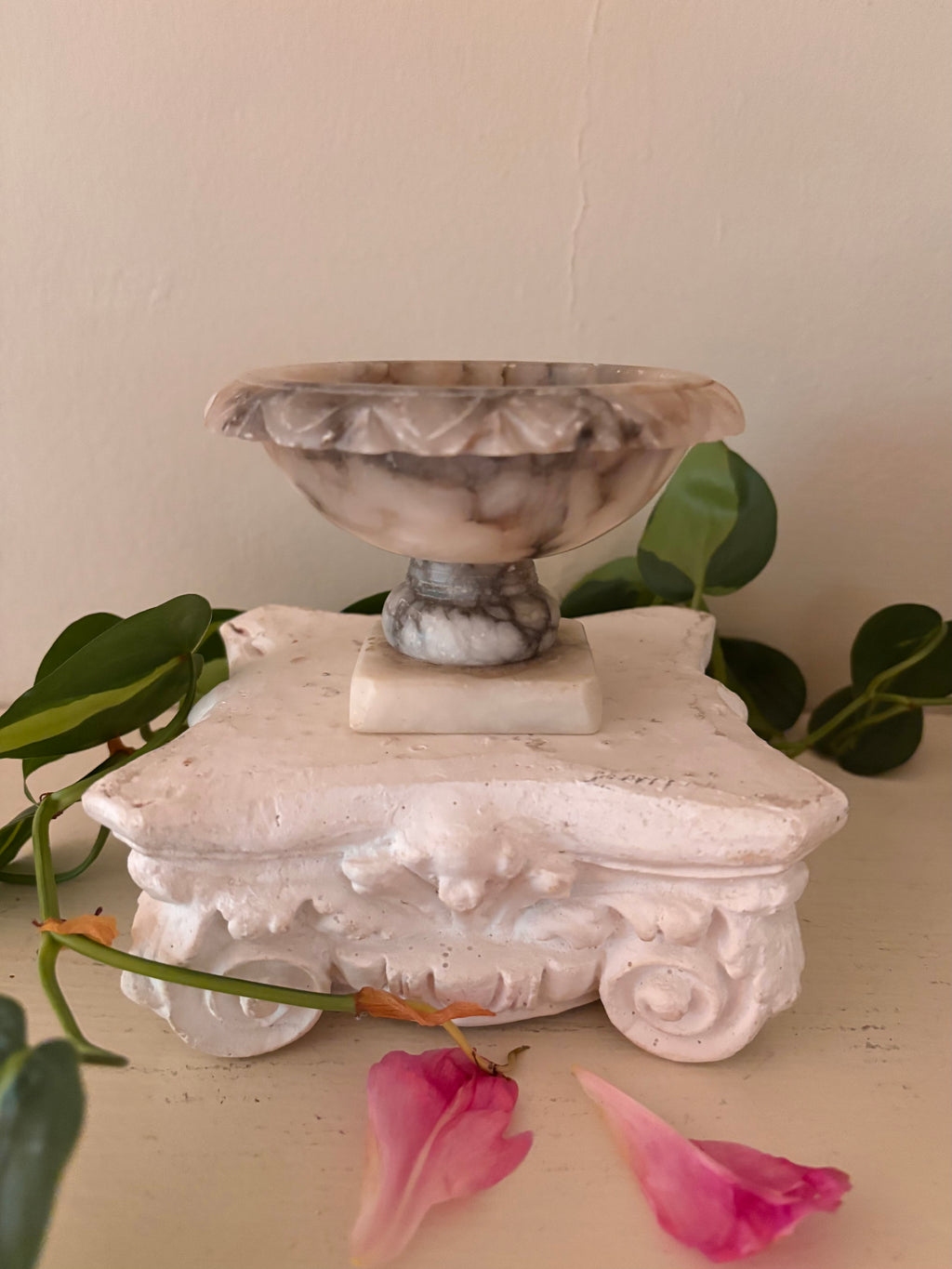 Marble footed compote with carved petal rim, cream and charcoal grey veined stone, short turned pedestal.