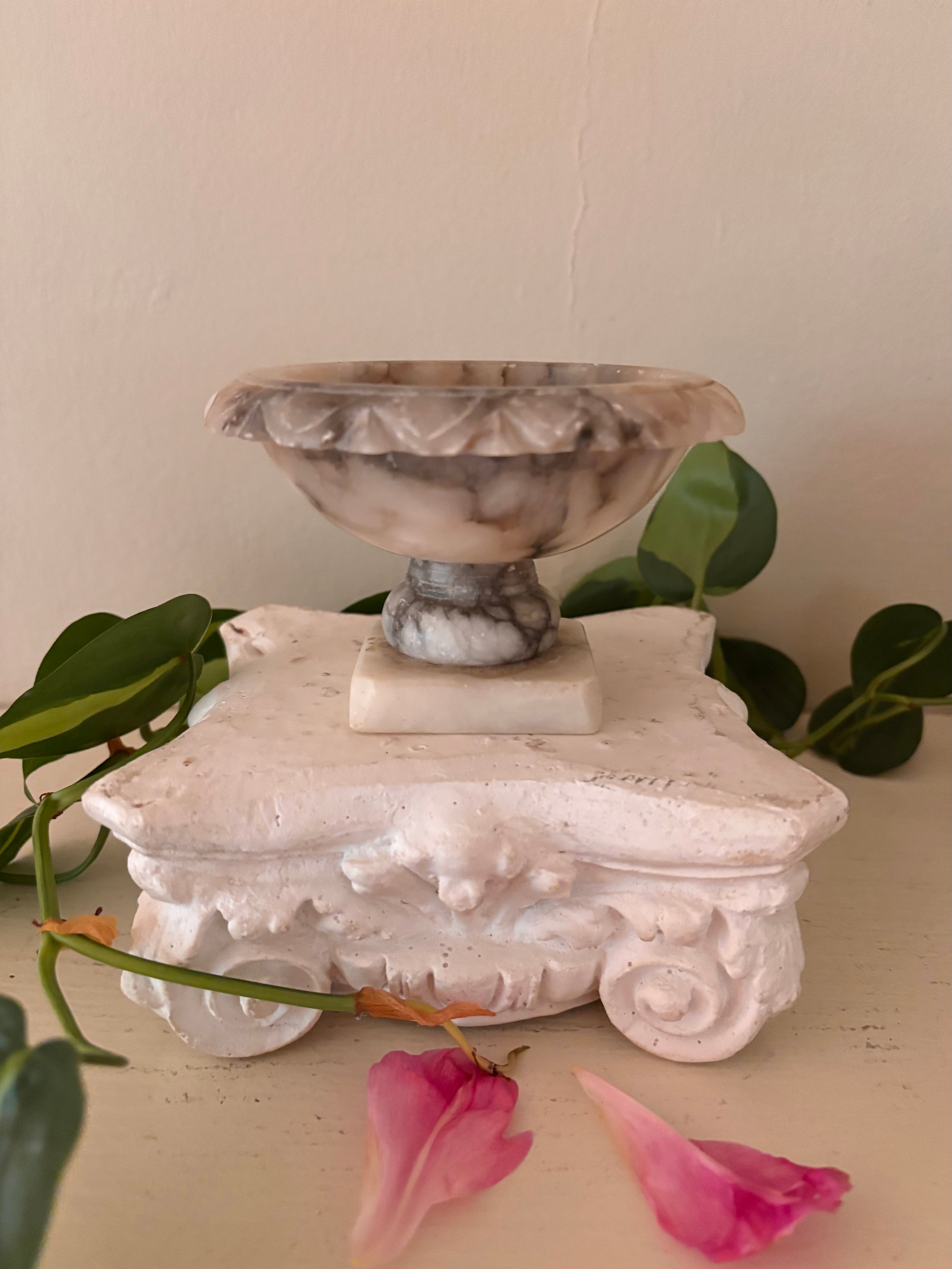 Marble footed compote with carved petal rim, cream and charcoal grey veined stone, short turned pedestal.