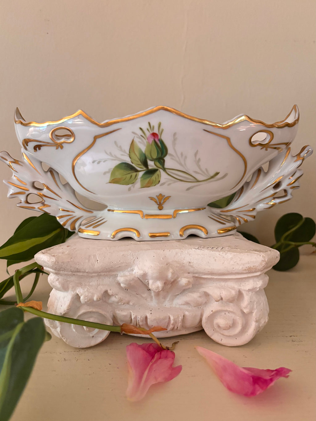 White porcelain centerpiece bowl with hand-painted floral bouquet cartouche and gilt acanthus handles.`