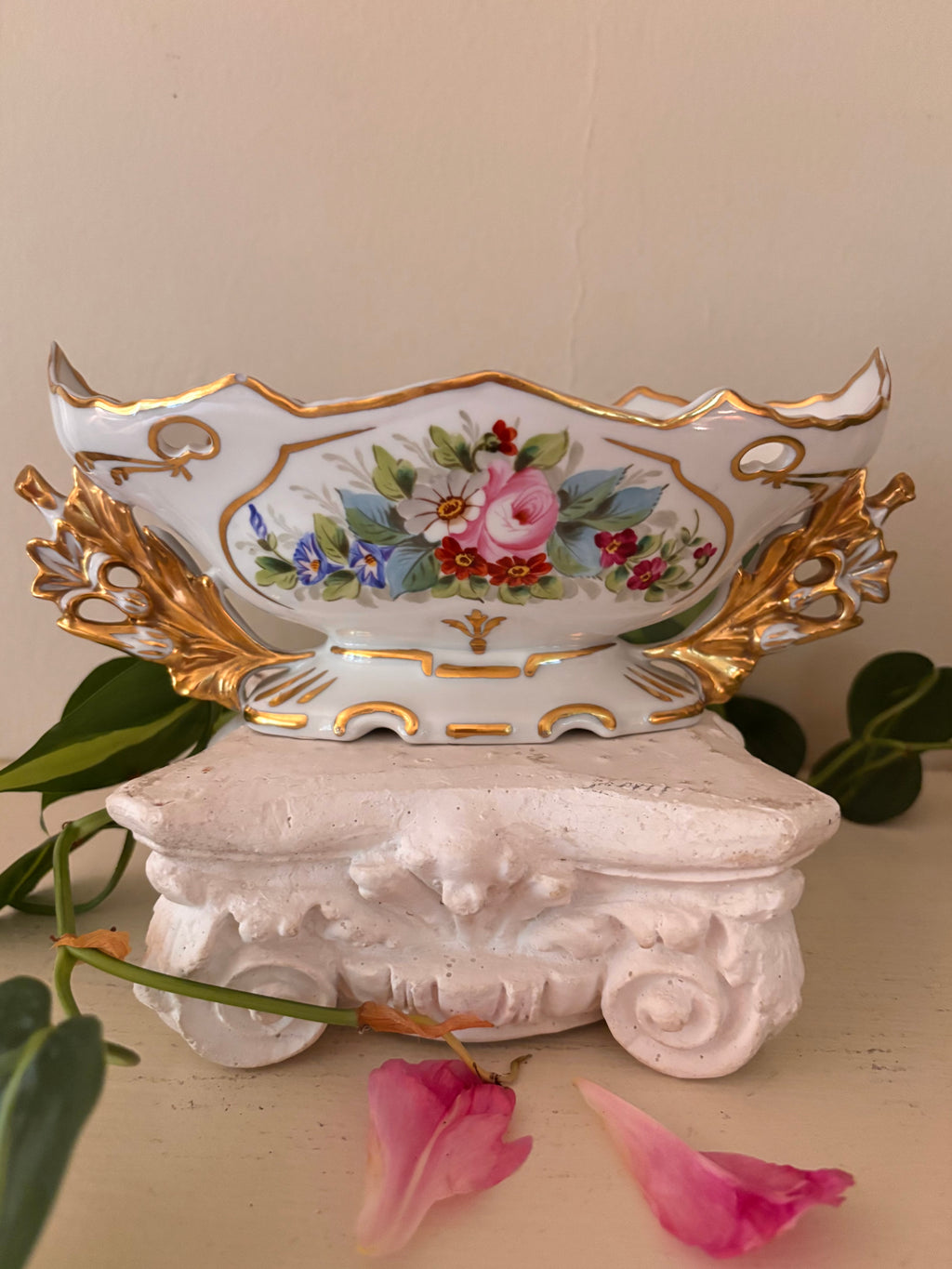 White porcelain centerpiece bowl with hand-painted floral bouquet cartouche and gilt acanthus handles.