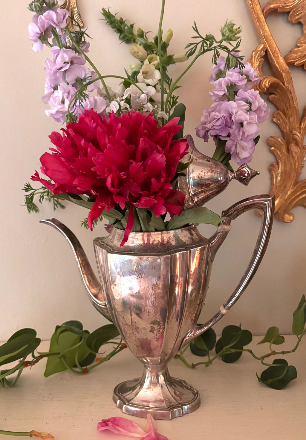 Silver-plate coffee pot with paneled body, long curved spout, and curved handle with bone insulators.