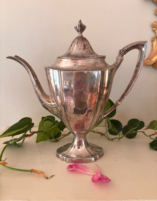 Silver-plate coffee pot with paneled body, long curved spout, and curved handle with bone insulators.
