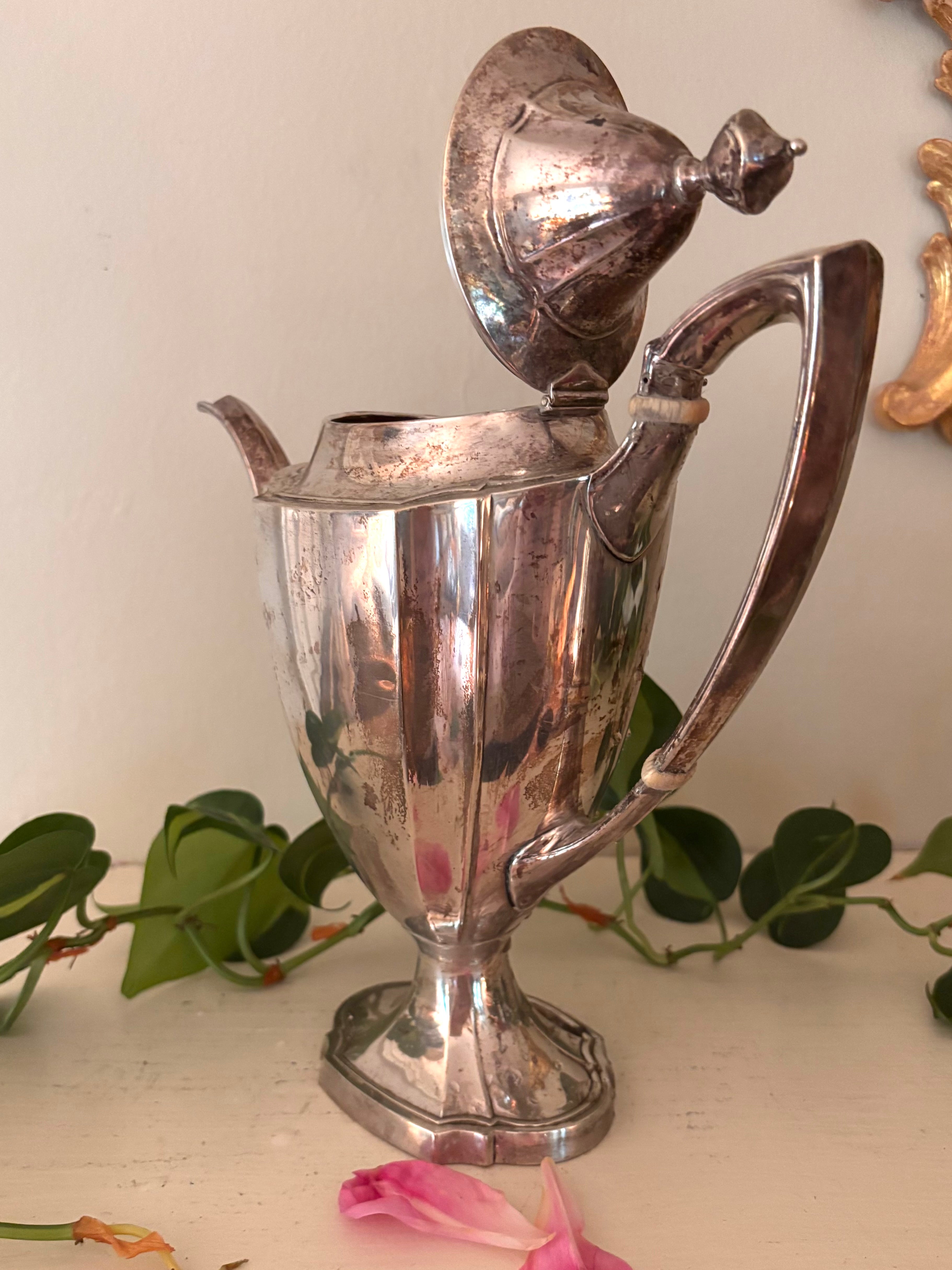 Silver-plate coffee pot with paneled body, long curved spout, and curved handle with bone insulators.