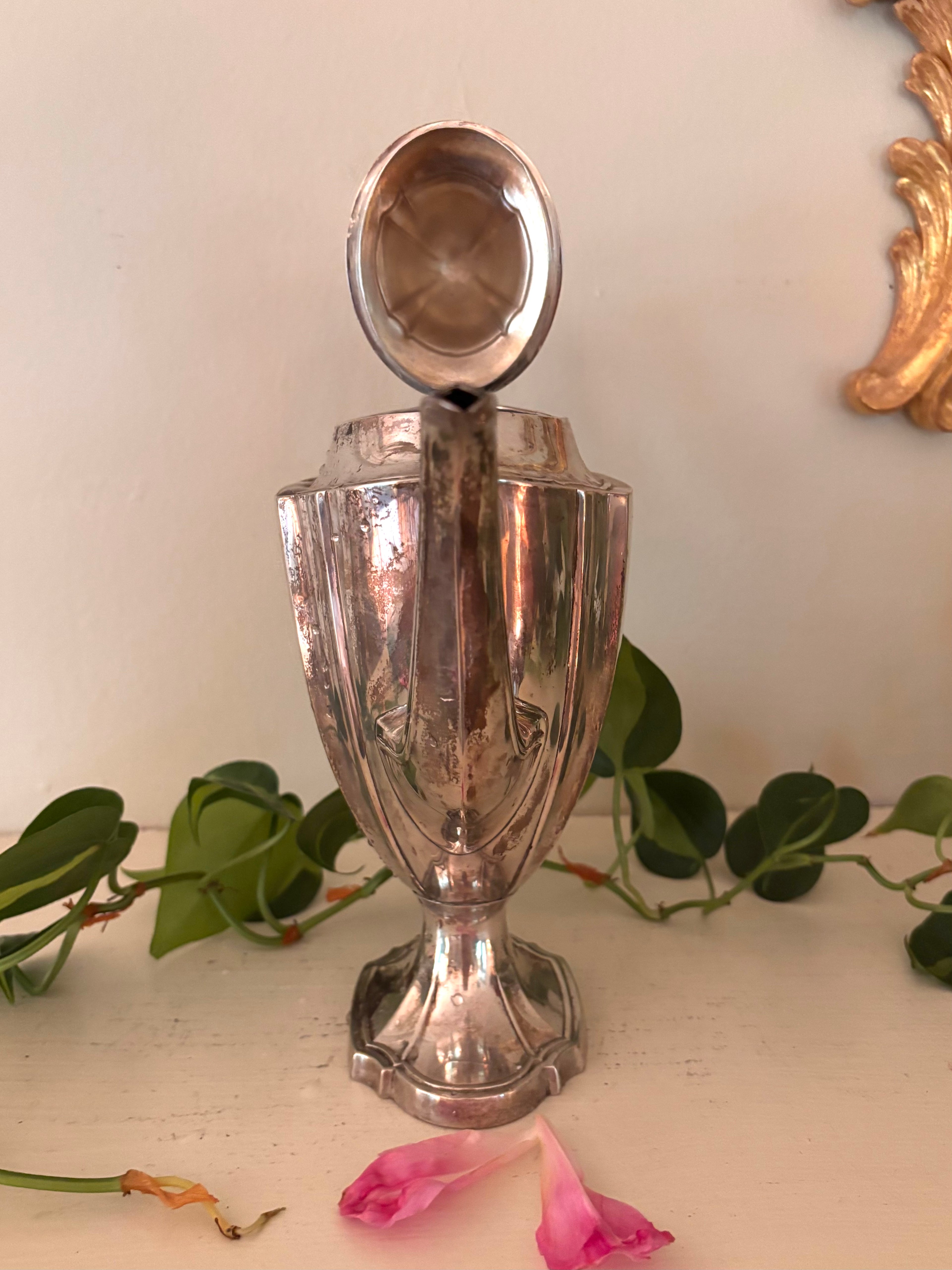 Silver-plate coffee pot with paneled body, long curved spout, and curved handle with bone insulators.