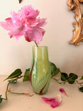 Hand-blown chartreuse green art glass vase with diagonal crimson swirl, curved organic form.