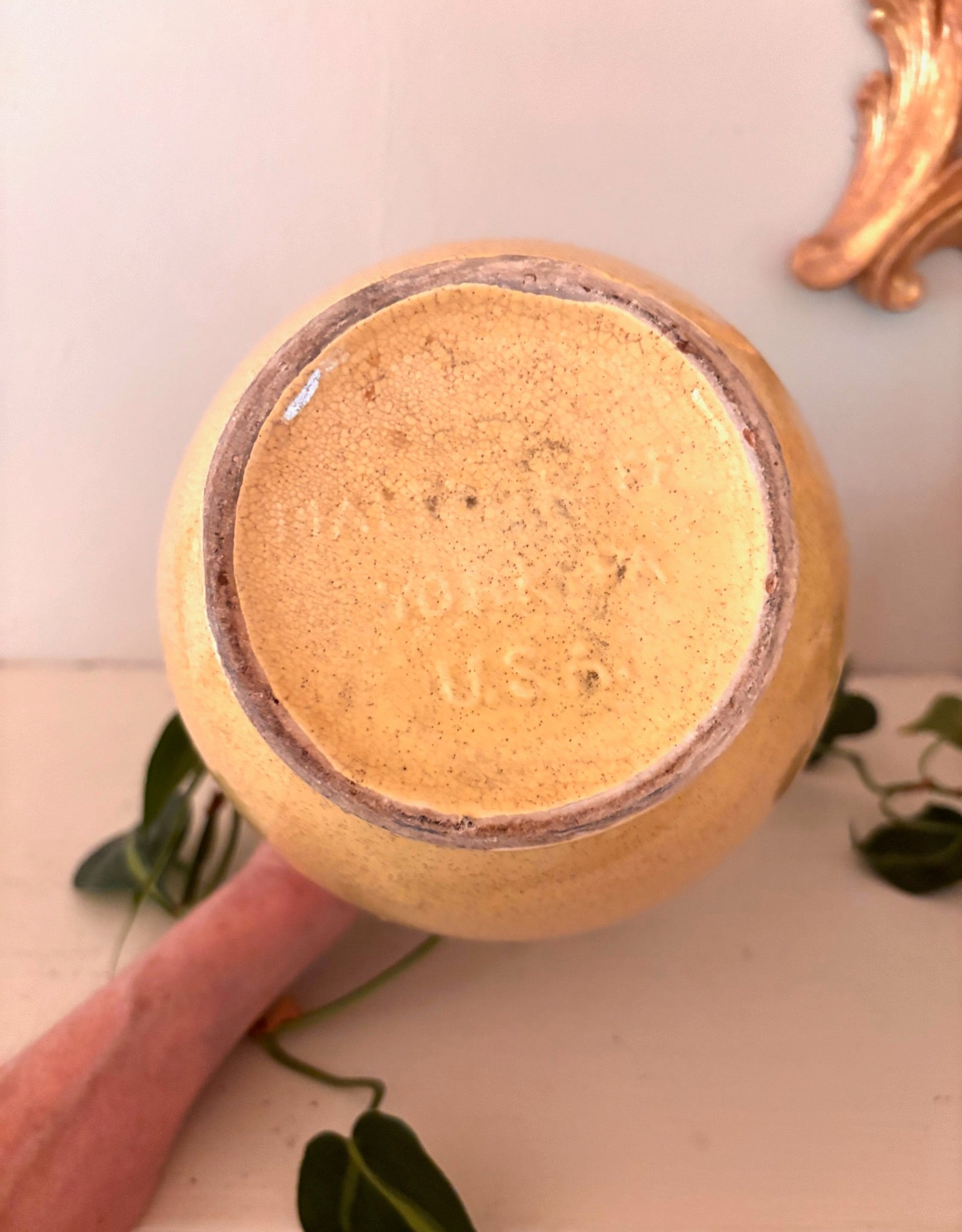 Base of speckled yellow ceramic jug showing embossed USA maker's mark.