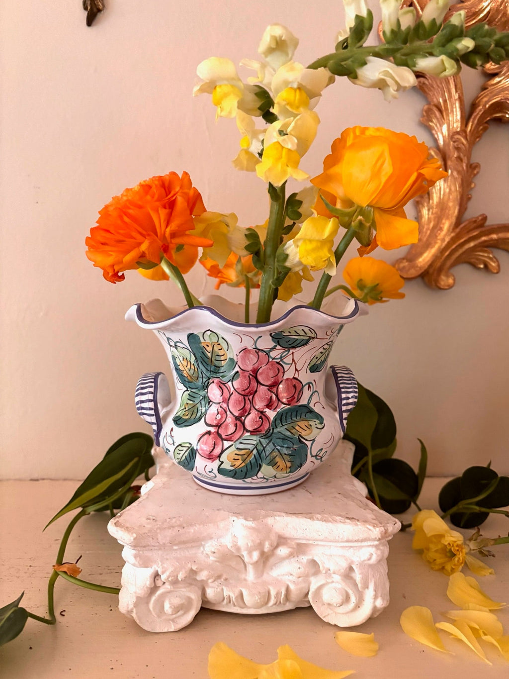 White Italian ceramic cachepot with hand-painted grape cluster, teal leaves, scalloped blue-edged rim and striped loop handles.