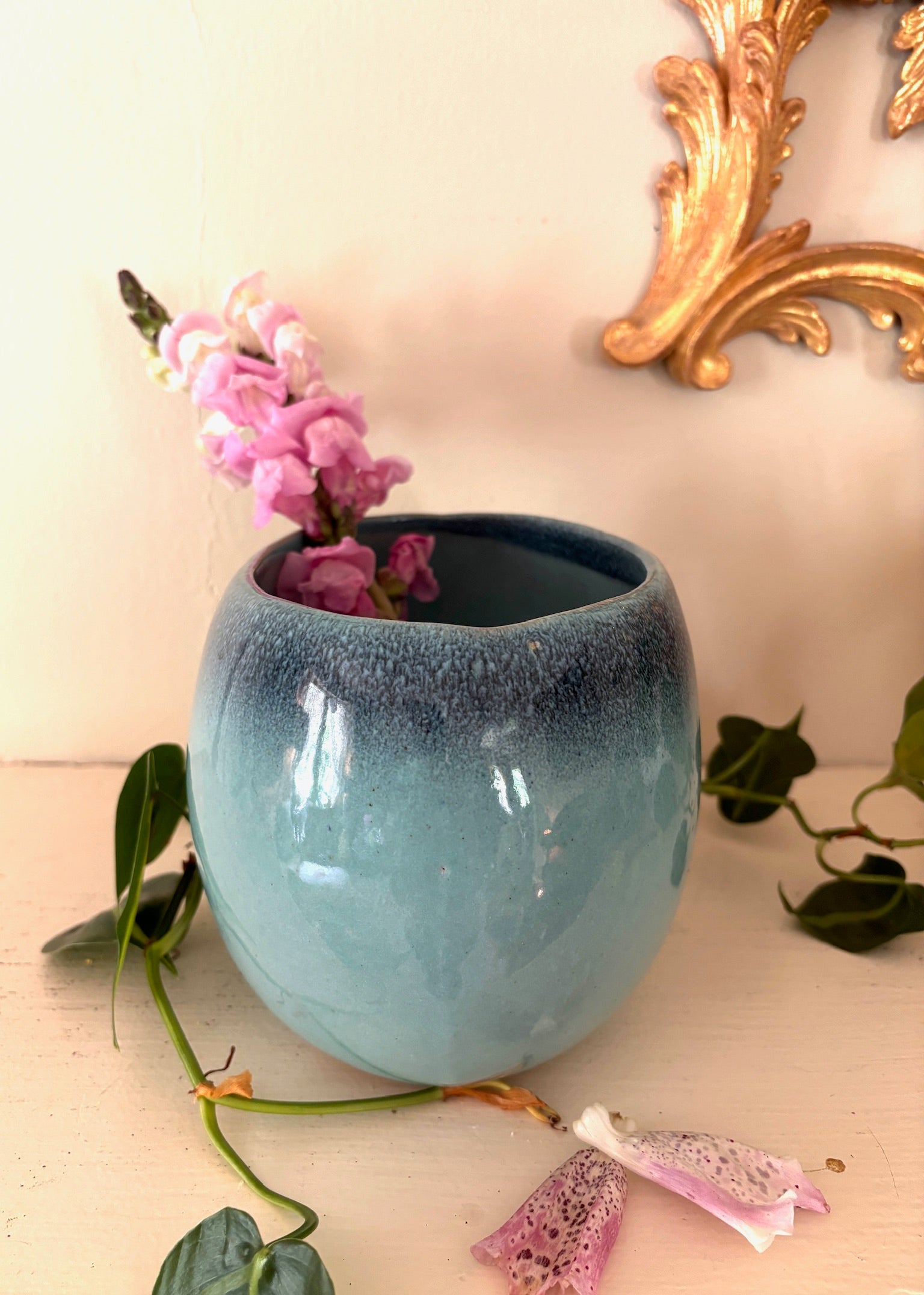 Side view of Glidden Pottery bowl showing pale aqua body and dark mottled indigo rim glaze.