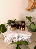 Brass-bridged opera glasses marked POLYCO and 3.5x with oxblood enamel barrels and a center focus screw.