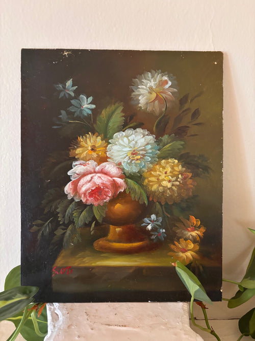 Signed oil painting floral still life in Dutch Golden Age style depicting a lush mixed bouquet with pink peony, white and yellow chrysanthemums, and blue flowers in a golden urn on a dark background, signed lower left in red