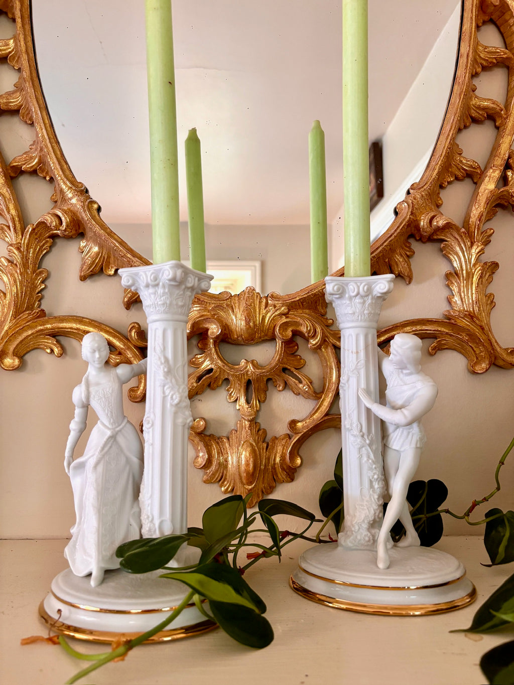 Pair of white bisque porcelain candle holders with fluted Corinthian columns and courting figures in period dress.