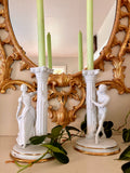 Pair of white bisque porcelain candle holders with fluted Corinthian columns and courting figures in period dress.