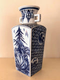 Square blue and white porcelain vase with twin handles, a landscape panel of pine and mountains, and lattice sides.