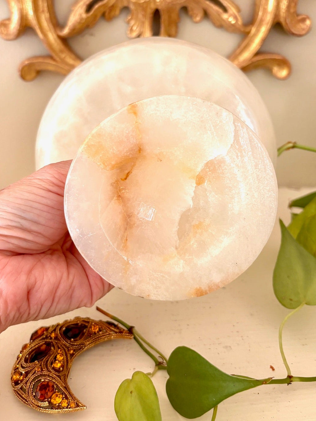 Underside of marbled stone pedestal bowl showing the translucent stone base.