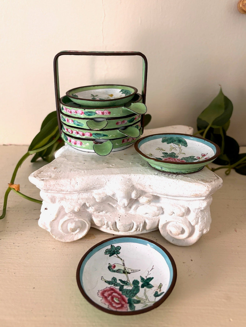Hand-painted Canton enamel dish with a bird and pink peonies, more enamel dishes behind.