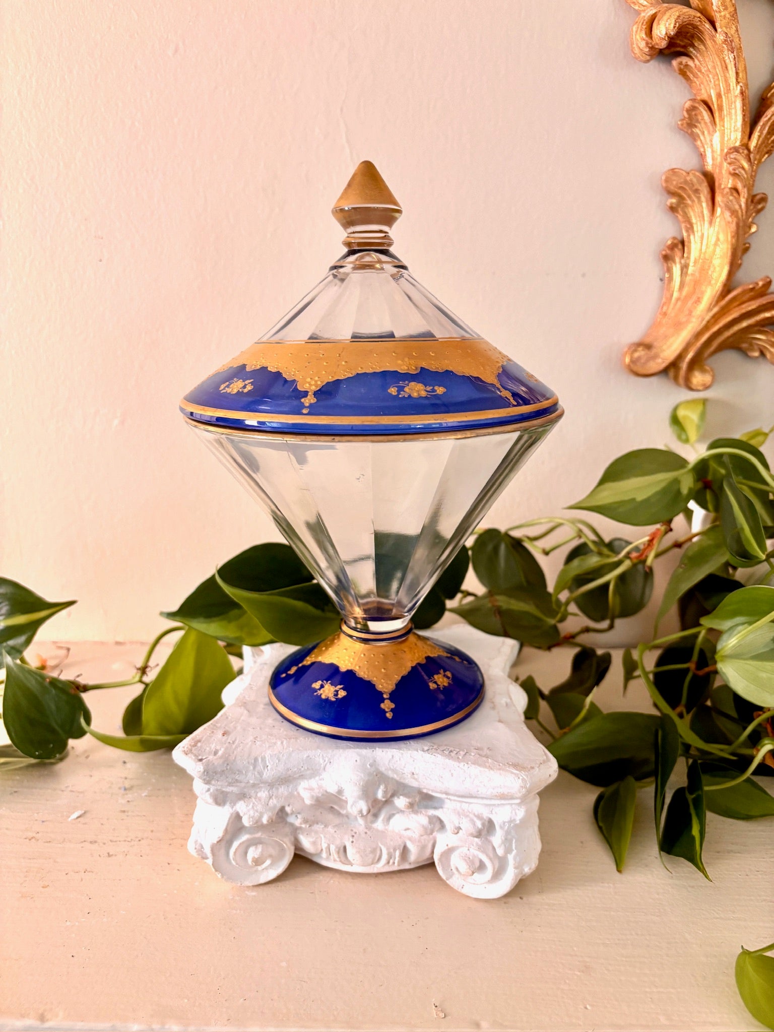 Side view of faceted glass lidded compote with cobalt and gold banding and pointed finial.