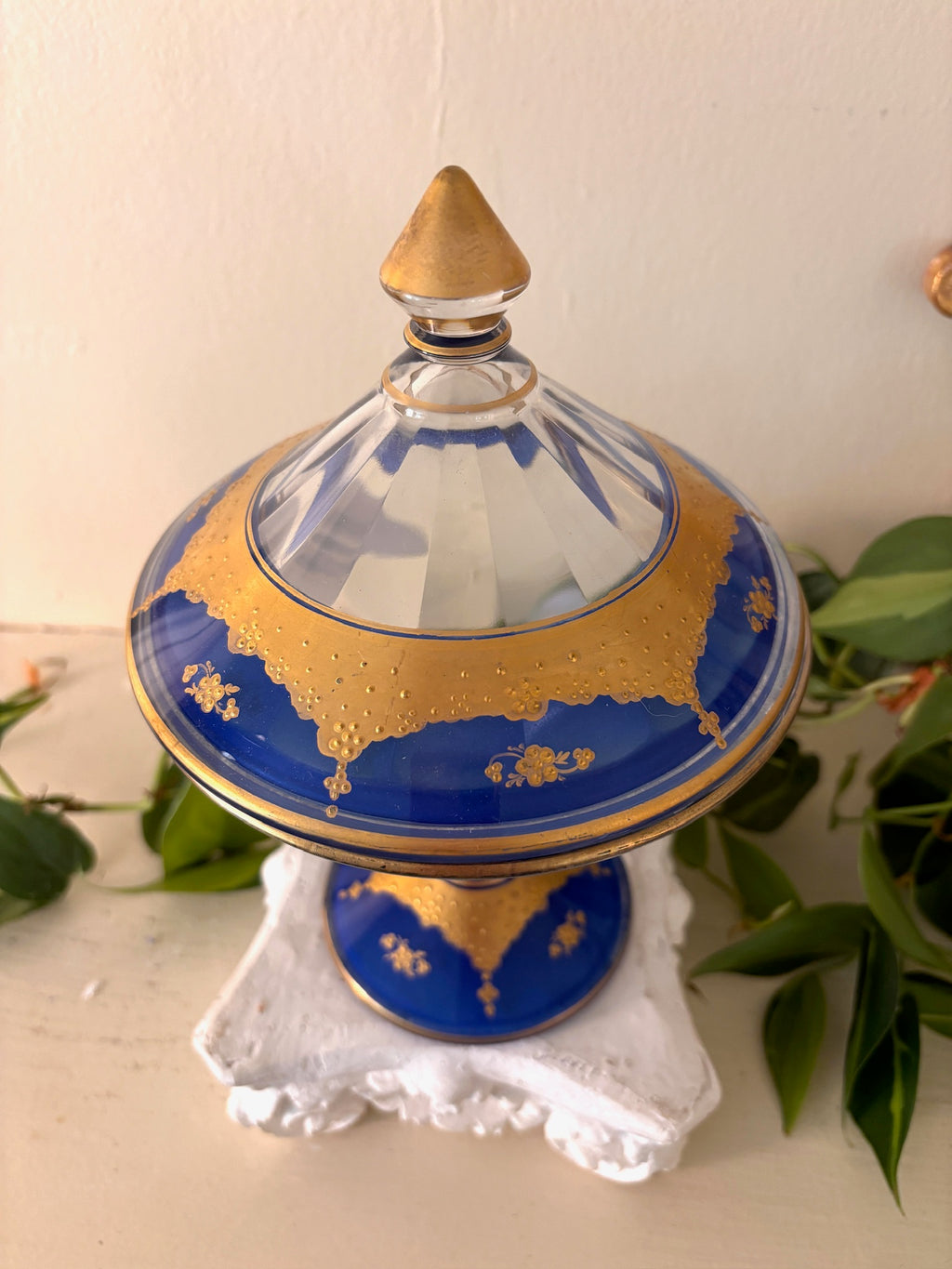 Close-up of gold gilt floral detail on cobalt blue glass lid.