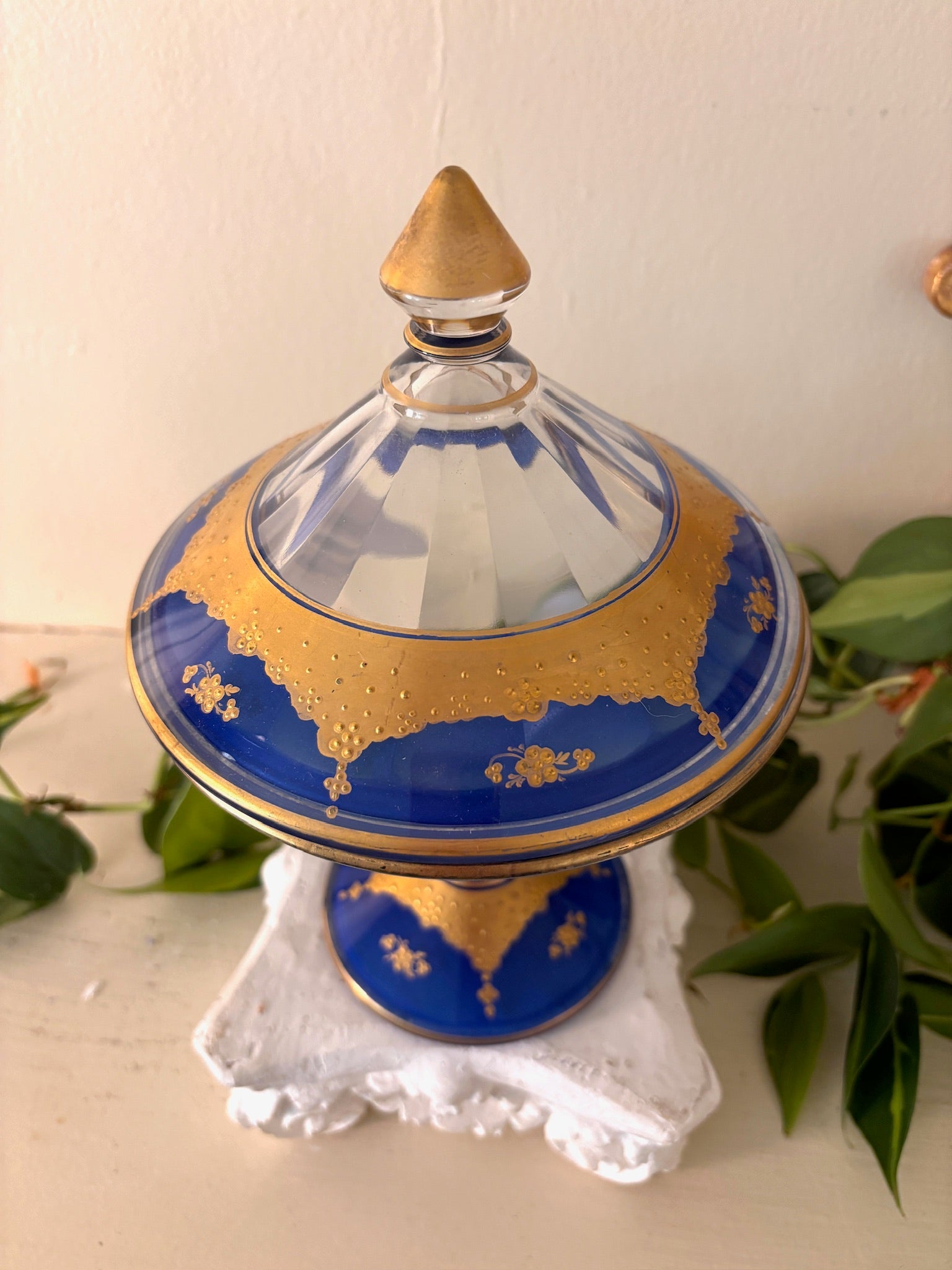 Close-up of gold gilt floral detail on cobalt blue glass lid.