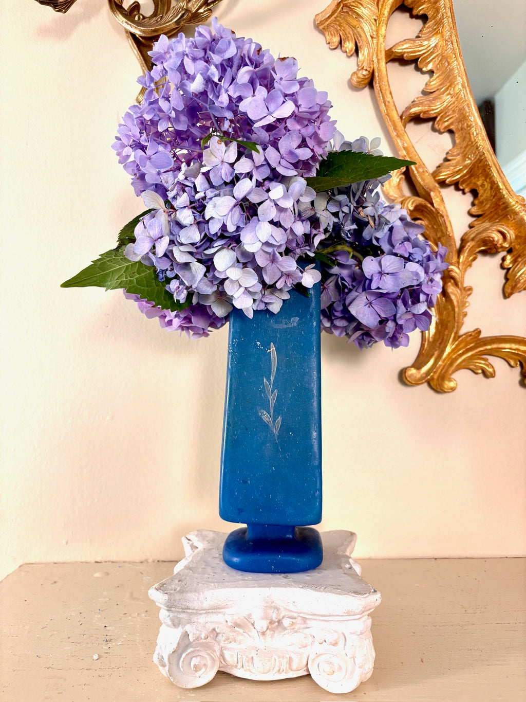 Frosted blue glass vase with hand-painted white branch motif on a footed base.