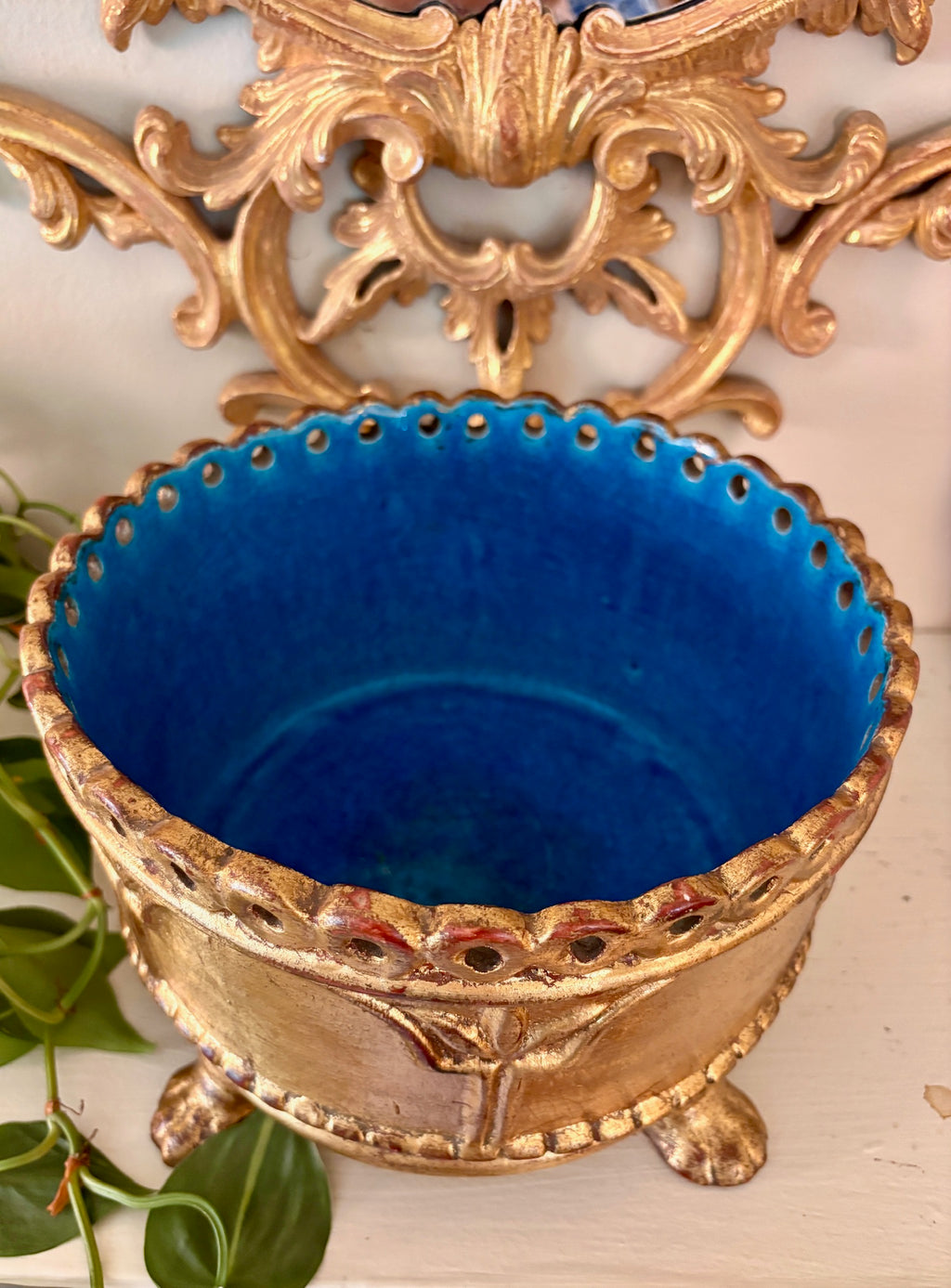 Close-up of gilded cachepot showing turquoise glazed interior and pierced gold rim.