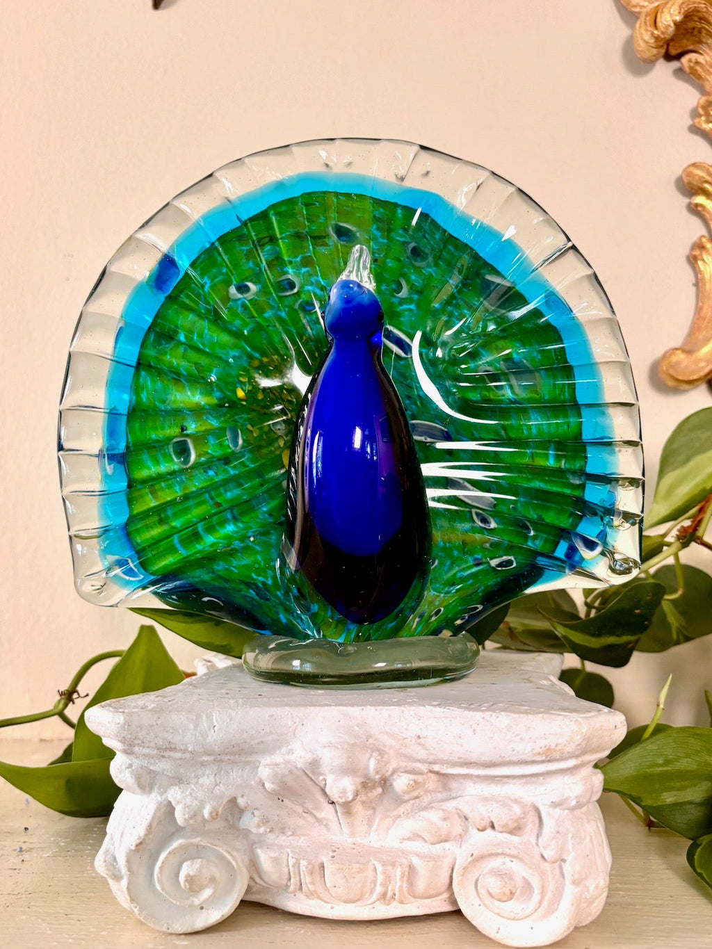 Hand-blown glass peacock figurine with emerald and turquoise fanned tail and cobalt blue body.
