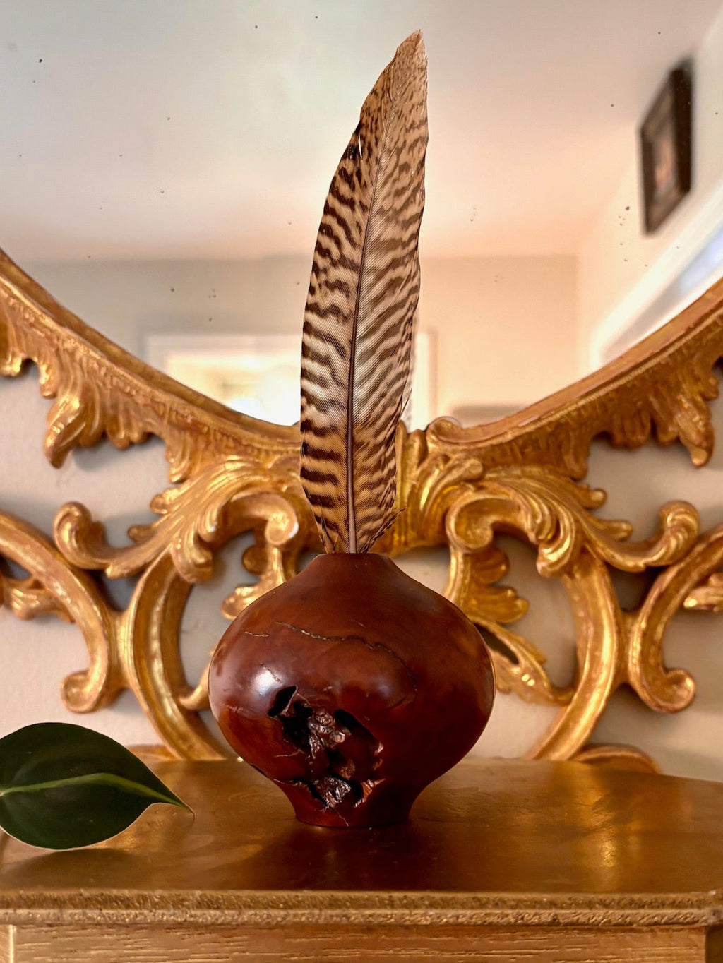 Hand-turned reddish-brown wood vessel with a natural void and a small top opening.