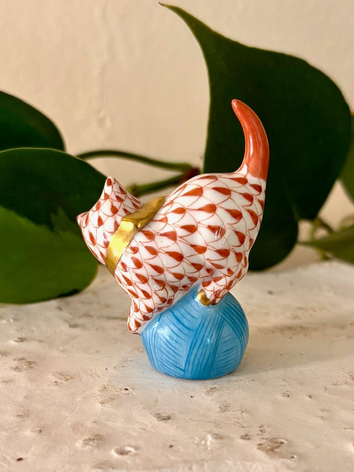 Back view of Herend rust fishnet pattern porcelain cat figurine with tail raised.