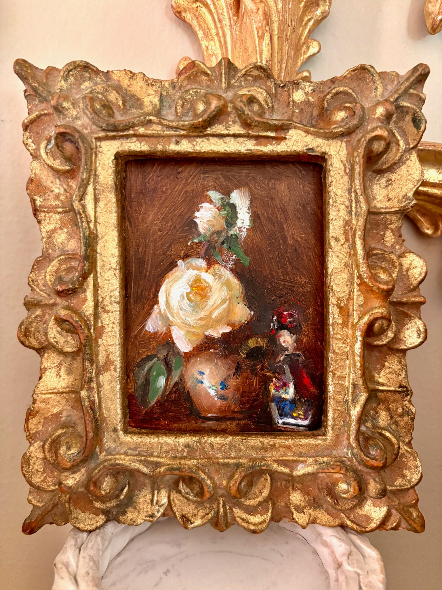 Small oil still life painting of white roses and a ceramic vase in a carved gilt frame.