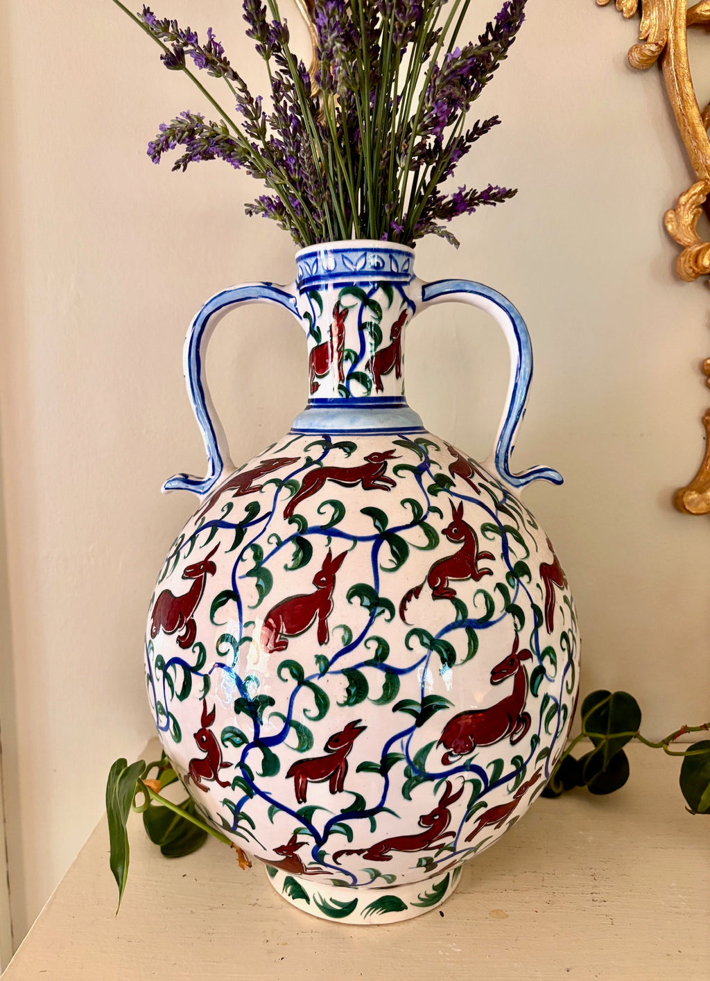 Large hand-painted Iznik pottery vase with cobalt blue, red, and green rabbit and vine motif, double handles.