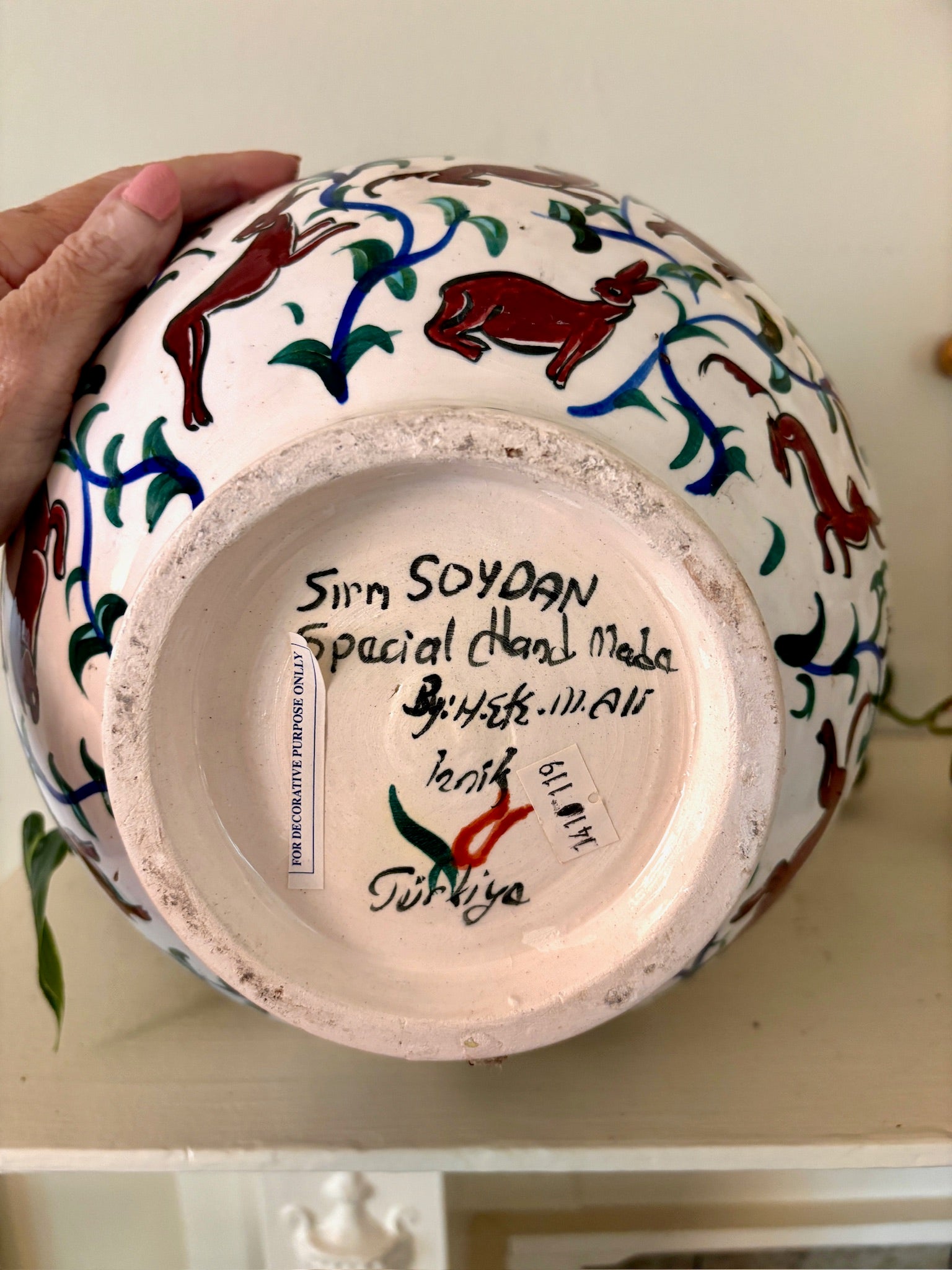 Underside of an Iznik pottery vase with the maker's handwritten signature and Iznik, Turkey inscription.