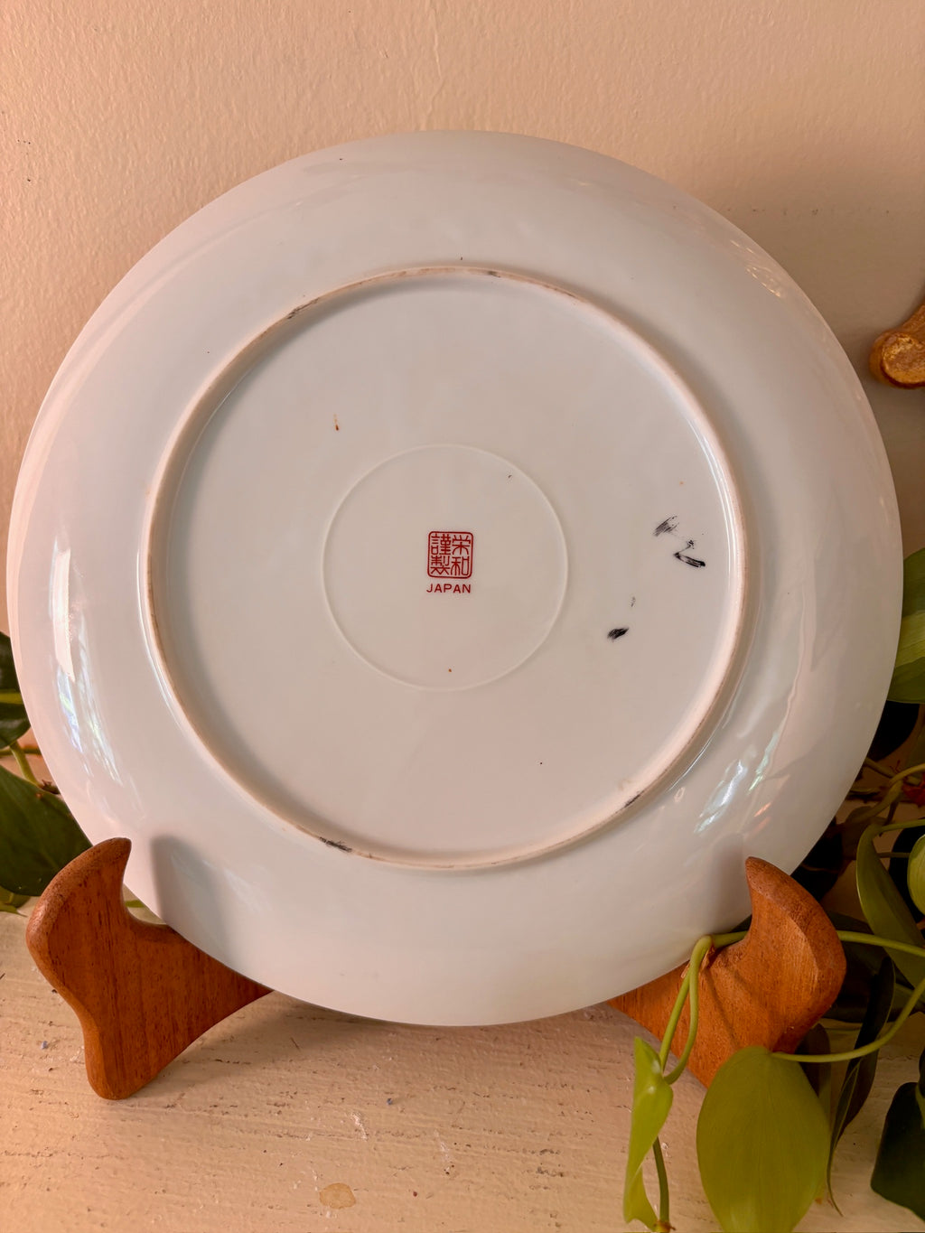 Back of Japanese porcelain plate showing red seal mark and "JAPAN" stamp.