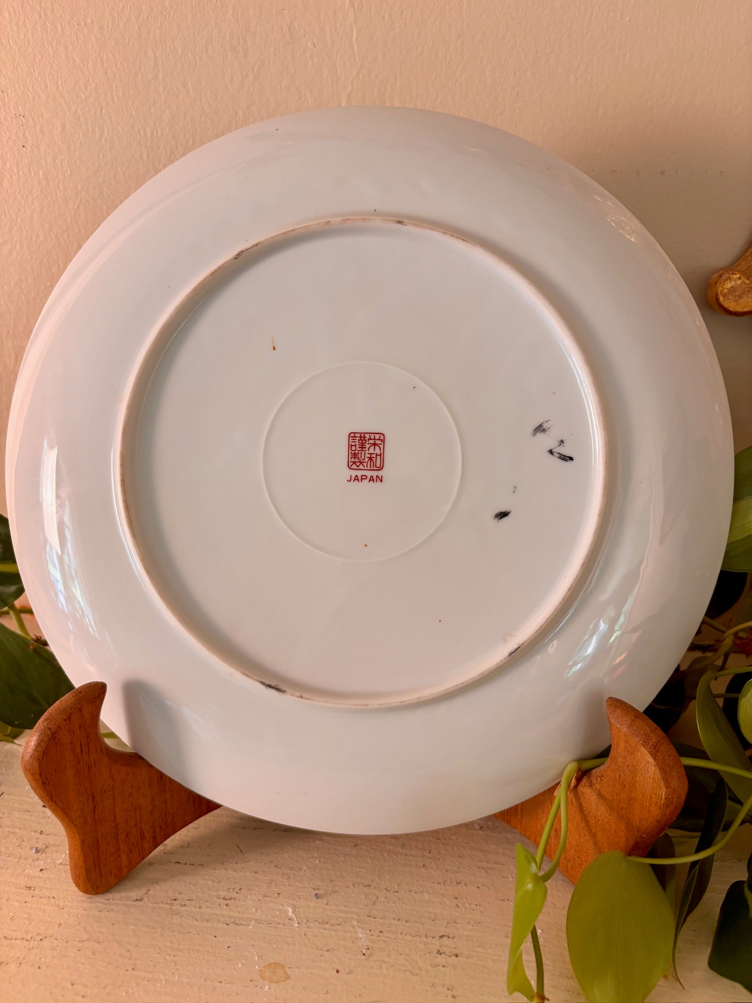 Back of Japanese porcelain plate showing red seal mark and "JAPAN" stamp.