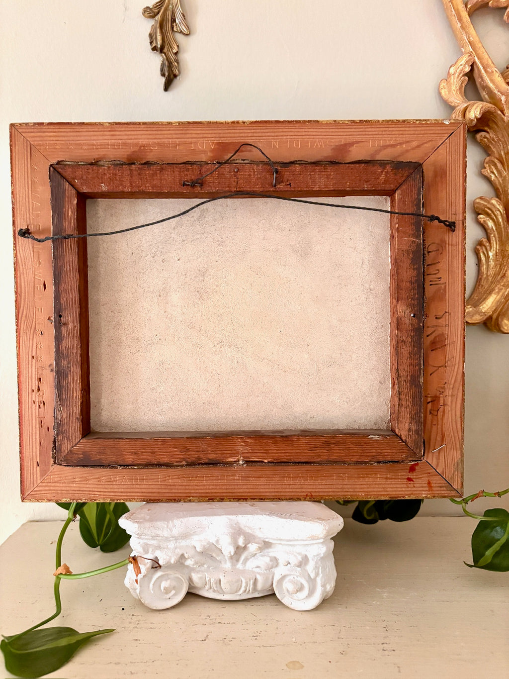 Back of a gilt picture frame stamped "Made in Sweden" along the wood edge.