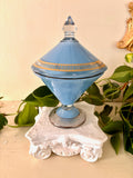 Opaline blue glass lidded compote with gold banding and a clear glass finial on a ribbed footed base.