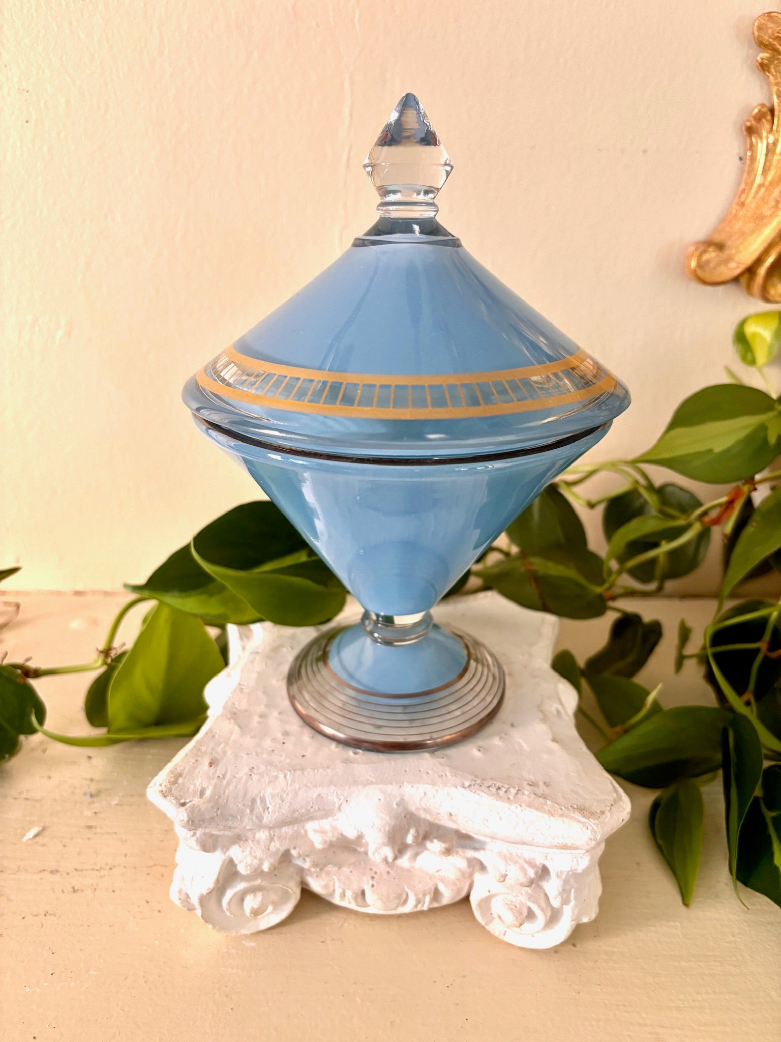 Opaline blue glass lidded compote with gold banding and a clear glass finial on a ribbed footed base.