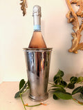 Tall tapered silver vase with beaded rims at the top and foot and a mirror-polished body.