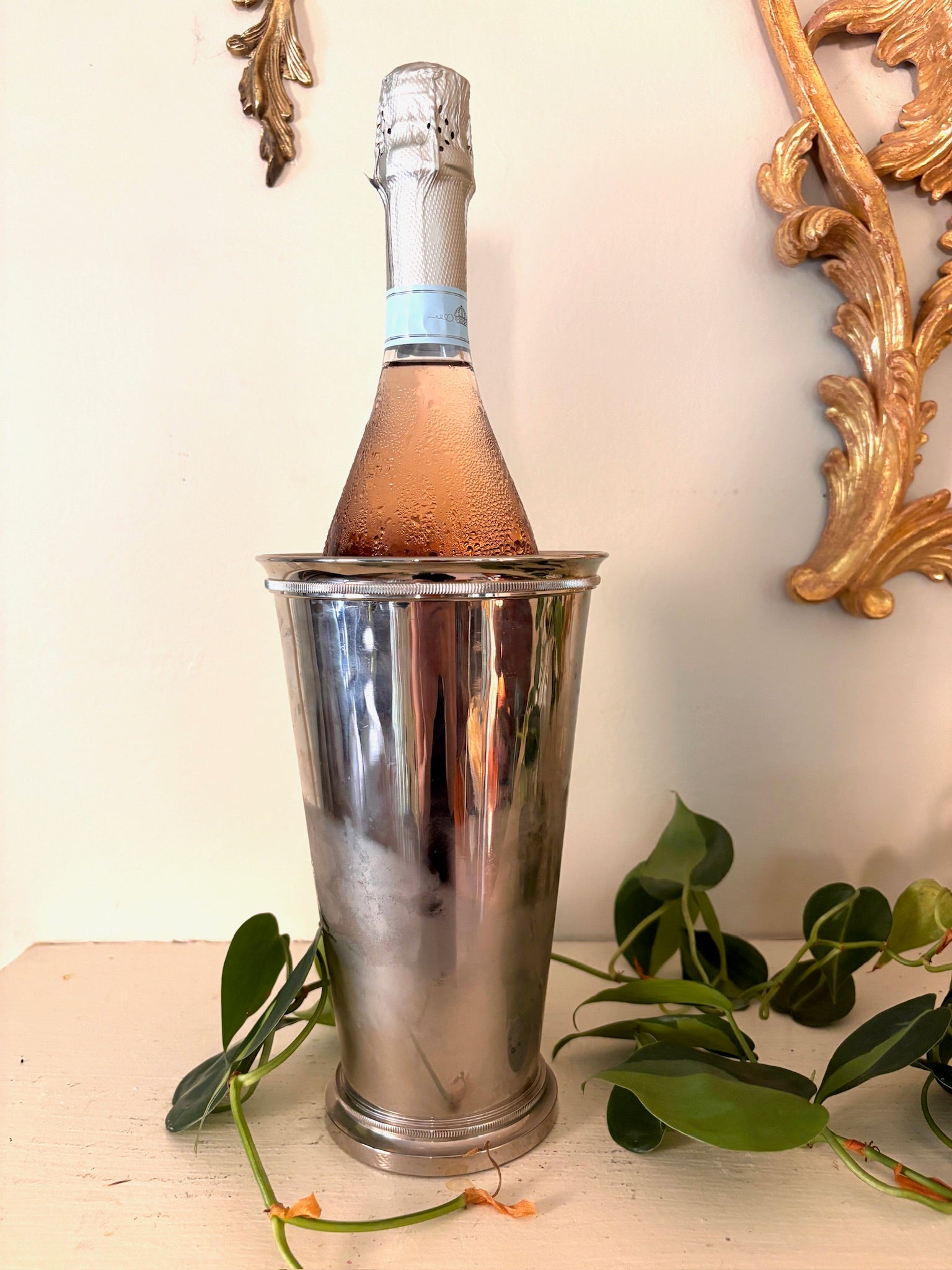 Tall tapered silver vase with beaded rims at the top and foot and a mirror-polished body.